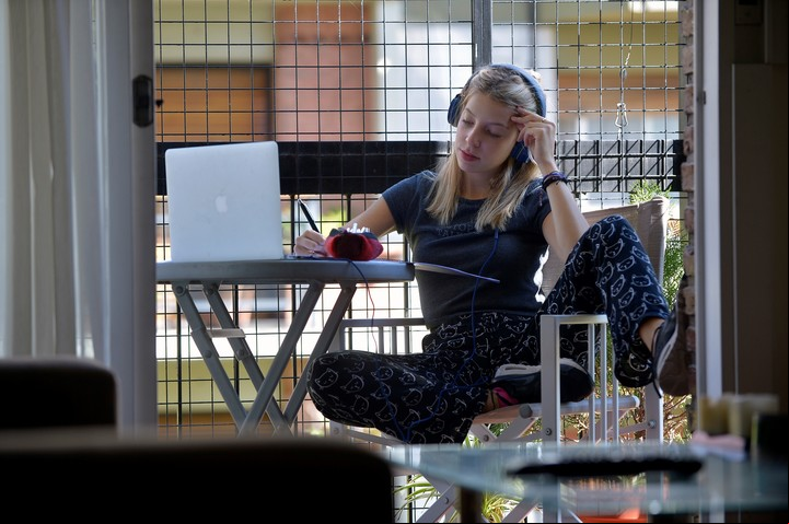 Renata escucha un audio y se prepara para hacer un trabajo de ingeniería química. Foto: Ariel Grinberg.