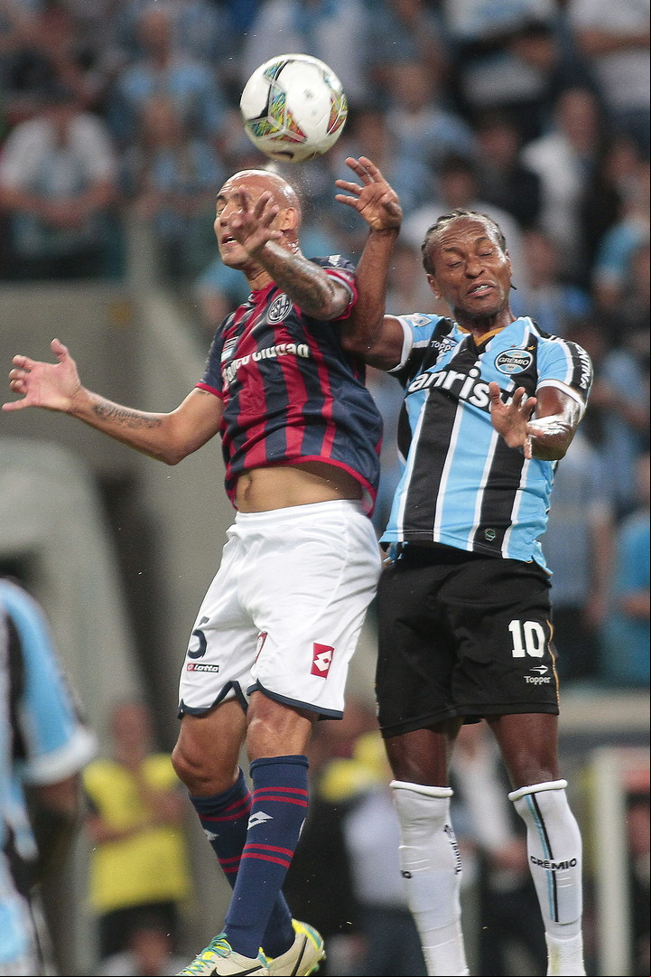 Zé Roberto (con la camiseta de Gremio) disputando el balón con Juan Mercier), en San Lorenzo, durante un partido de la Copa Libertadores 2014, en el estadio Arena do Gremio, de Porto Alegre. (Foto: EFE/Neco Varella).