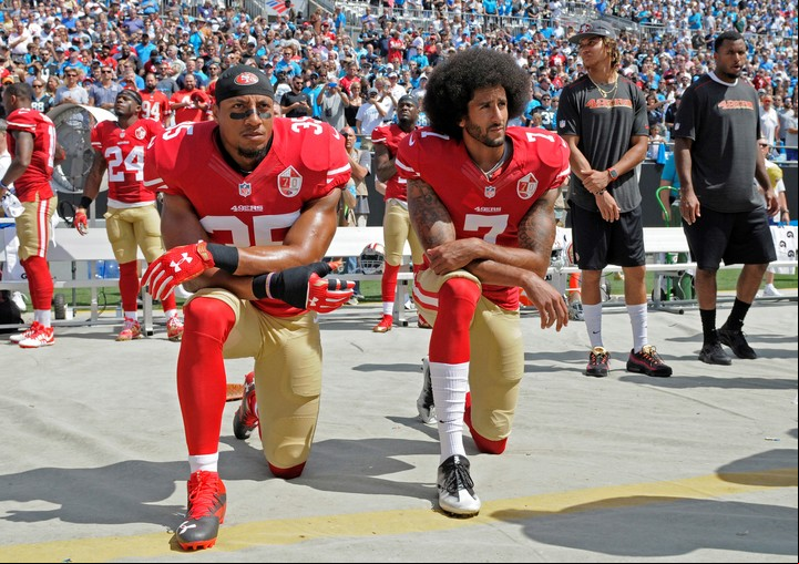 Colin Kaepernick y Eric Reid se arrodillan en señal de protesta por crímenes raciales. Foto AP