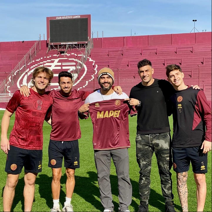 Ignacio Serricchio junto a varios jugadores, en su paso por la cancha de Lanús.