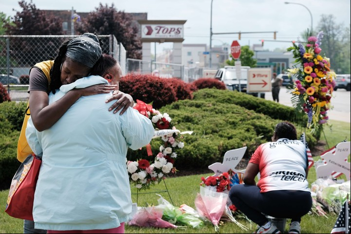 La gente se abraza cerca de un monumento a las víctimas del tiroteo fuera de la tienda de comestibles Tops el 20 de mayo de 2022 en Buffalo, Nueva York. Payton Gendron, de 18 años, está acusado del tiroteo masivo que mató a 10 personas en la tienda de comestibles Tops en el lado este de Buffalo el 14 de mayo y está siendo investigado como un crimen de odio. Spencer Platt/Getty Images/AFP