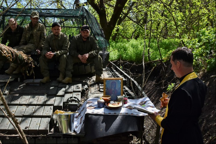 El capellán militar Serhiy celebrando un servicio religioso cerca de un tanque y su tripulación durante las celebraciones de Pascua cerca del frente en la zona de Zaporiya, Ucrania. Foto EFE