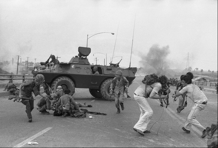 El 28 de abril de 1975, tropas survietnamitas y periodistas de la televisión occidental corren a refugiarse mientras un proyectil de mortero norvietnamita explota en el puente de Newport, a las afueras de Saigón. Foto AP