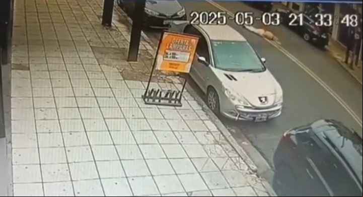 La mujer, tirada en el medio de la calle, tras caer del auto que un delincuente le robó en Ramos Mejía.